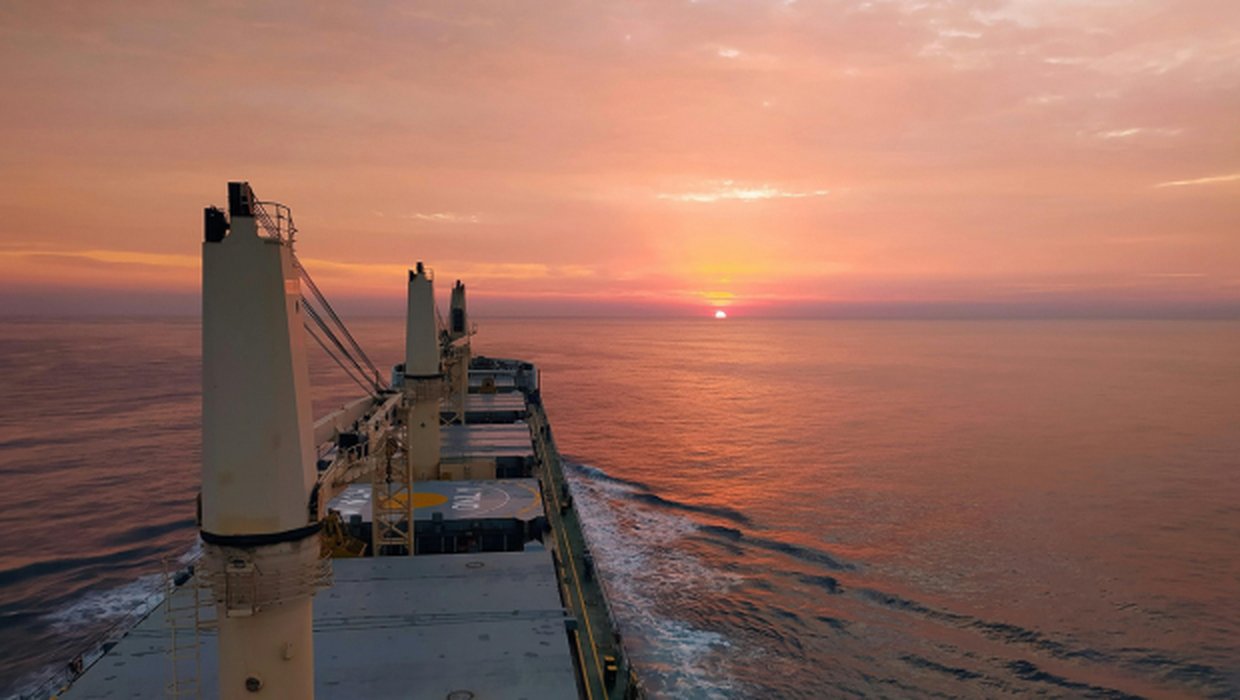 Cargo ship at sunset on open water